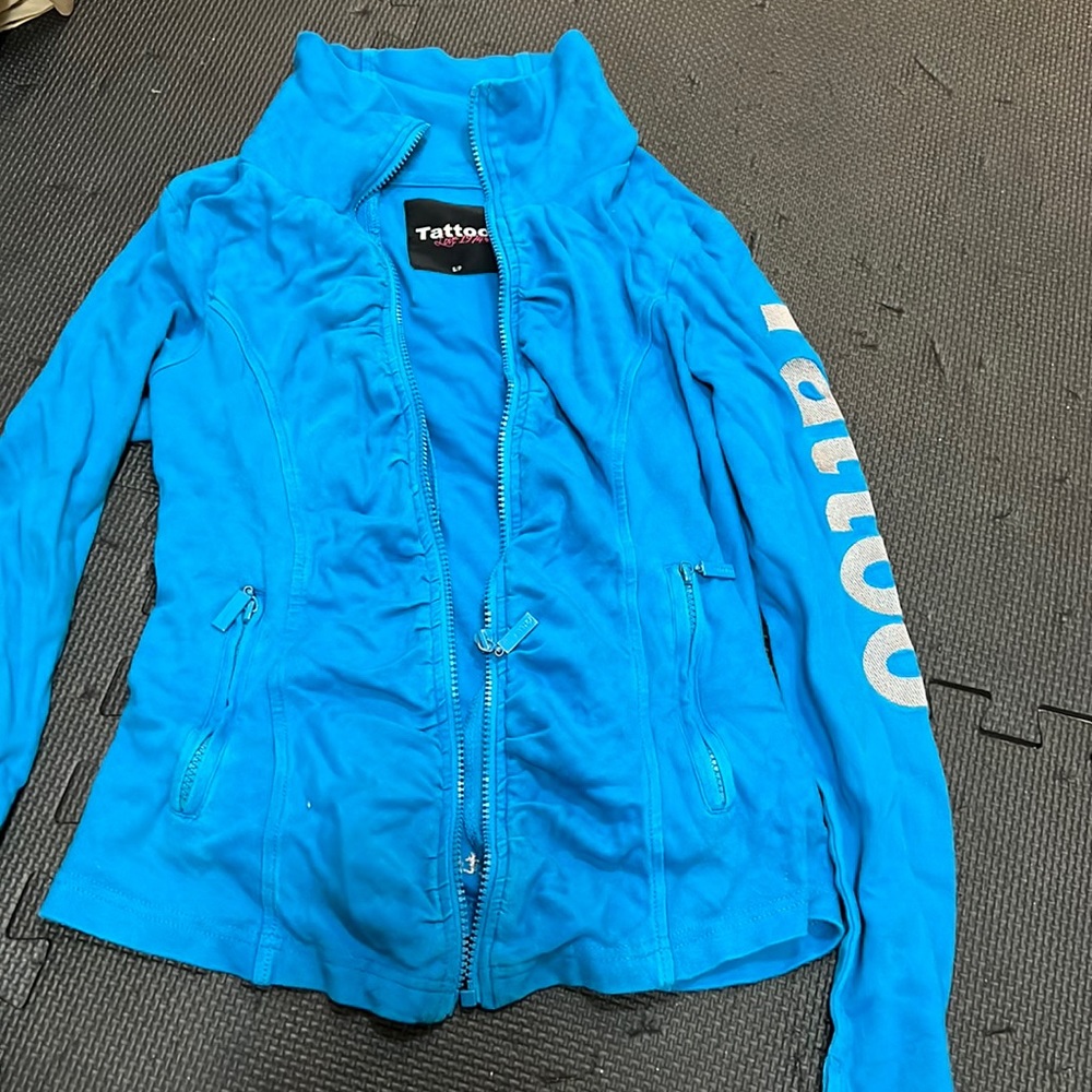Tattoo brand, blue sweater jacket.